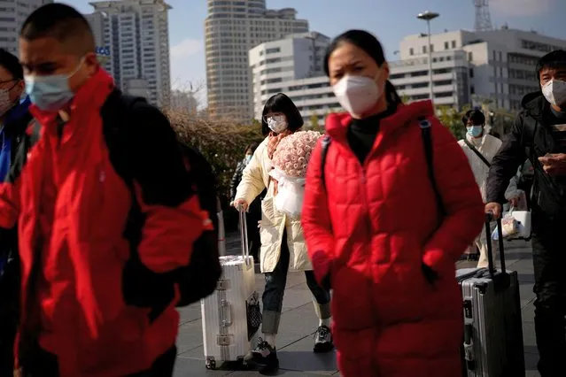 People walk with their luggage at a railway station during the annual Spring Festival travel rush ahead of the Chinese Lunar New Year, as the coronavirus disease (COVID-19) outbreak continues, in Shanghai, China on January 16, 2023. (Photo by Aly Song/Reuters)