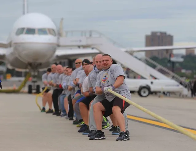 Members of the Bergen County Sheriff's Department, pull a Boeing 737 down the tarmac during The Plane Pull contest for Special Olympics at Newark Airport in Newark, N.J., Saturday, September 24, 2016. (Photo by Chris Pedota/The Record via AP Photo)