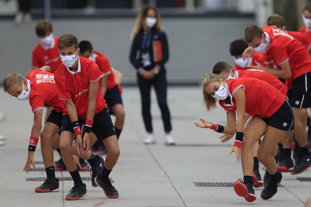Ball girls and boys exercise before relaying others on second round matches of the French Open tennis tournament at the Roland Garros stadium in Paris, France, Wednesday, September 30, 2020. (Photo by Michel Euler/AP Photo)