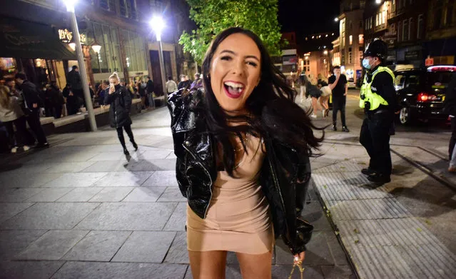 A young lady poses for the camera as police steward boozers away from pubs and bars in Newcastle, United Kingdom on October 23, 2020. The extra restrictions which servely limits social mixing in hospitality venues will come into effect on October 23, 2020. (Photo by North News and Pictures/The Sun)