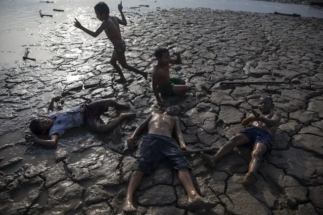 Children play a game of soldiers on the banks of the Ucayali River in Palestina, in Peru's Ucayali region, Peru, Wednesday, September 30, 2020. The Ucayali region located along a muddy river has long seen periodic dengue outbreaks, though this year's figures are already three times that seen in 2019. (Photo by Rodrigo Abd/AP Photo)
