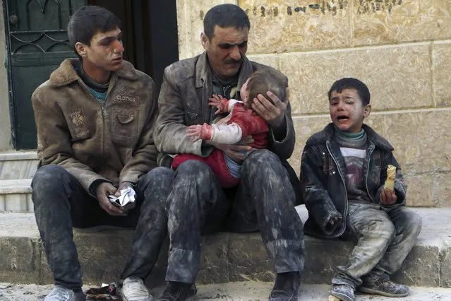A man holds a baby saved from under rubble, who survived what activists say was an air strike by forces loyal to Syrian President Bashar al-Assad, in Masaken Hanano in Aleppo, in this February 14, 2014 file photo. (Photo by Hosam Katan/Reuters)
