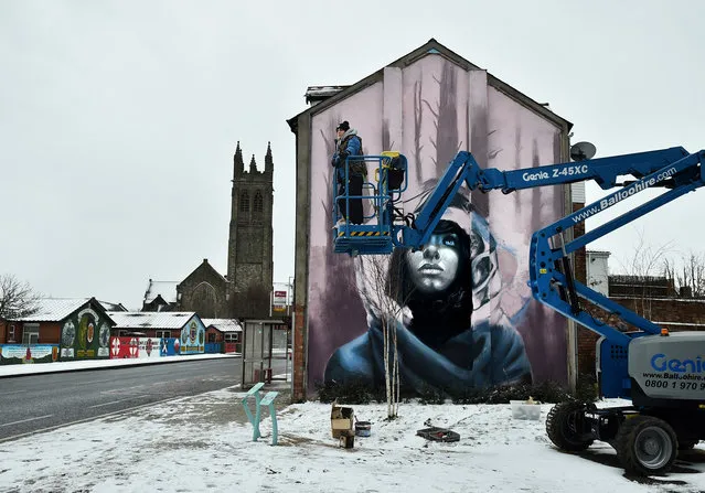Joy Gilleard one half of the street art duo Nomad Clan looks out across the Belfast landscape as she continues work on the Newtownards road on March 1, 2018 in Belfast, Northern Ireland. (Photo by Charles McQuillan/Getty Images)