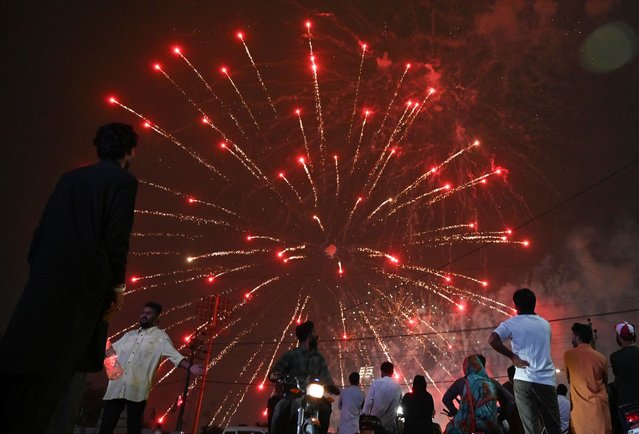 People watch a firework displayed in front of the National Stadium during Pakistan's 78th anniversary of Independence Day celebrations in Karachi on August 14, 2025. (Photo by Asif Hassan/AFP Photo)