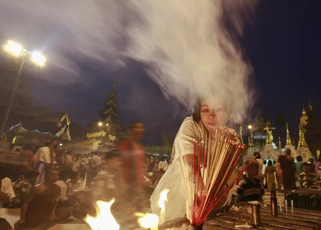 A woman lights frankincense as she prays at Shwedagon pagoda on the first day of Myanmar's traditional New Year in Yangon April 17, 2013. (Photo by Soe Zeya Tun/Reuters)