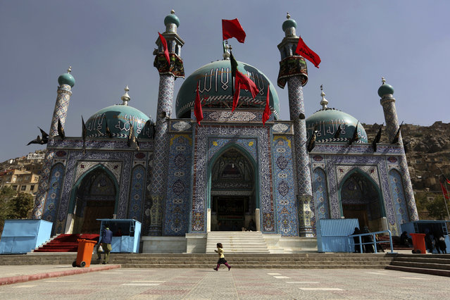 In this Sunday, October 9, 2016. photo, an Afghan Shiite girl runs in front of the Karti Sakhi shrine during a commemoration of Ashoura in Kabul, Afghanistan. (Photo by Rahmat Gul/AP Photo)