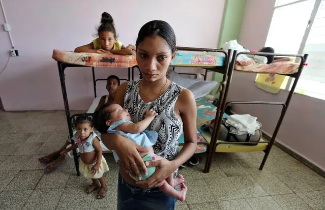A woman holds her baby in a shelter in Guantanamo, Cuba, on 03 October 2016, at the approach of Matthew Hurricane. Six provinces in Cuba, are on “hurricane alert” waiting for the potential impact of Matthew Hurricane which is expected to make landfall by Guantanamo, reported the National Staff of the Civil Defense of the island. (Photo by Alejandro Ernesto/EPA)