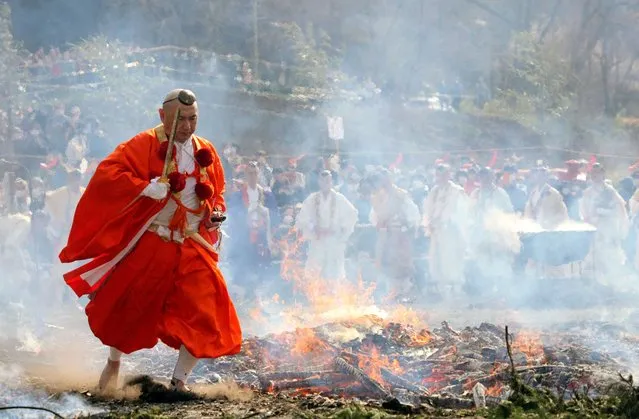 A Buddhist monk walks barefoot over hot coal and through flames during the annual fire walking festival of Takao-san Yakuo-in temple in Hachioji, Tokyo suburbs, Japan, 12 March 2023. Monks and 1,000 worshipers participated in the fire walking festival, or Hiwatari matsuri, praying for protection against sickness, for safety within the family and peace in the world. (Photo by Franck Robichon/EPA/EFE/Rex Features/Shutterstock)