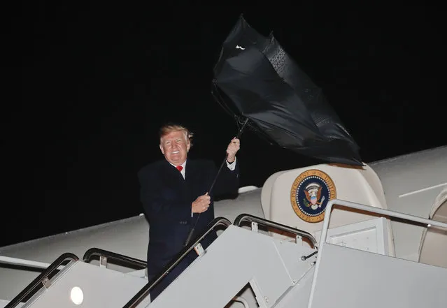 U.S. President Donald Trump's umbrella is turned inside out by a gust of wind while stepping off Air Force One during his arrival at Andrews Air Force Base, Md., Saturday, April 28, 2018. (Photo by Pablo Martinez Monsivais/AP Photo)