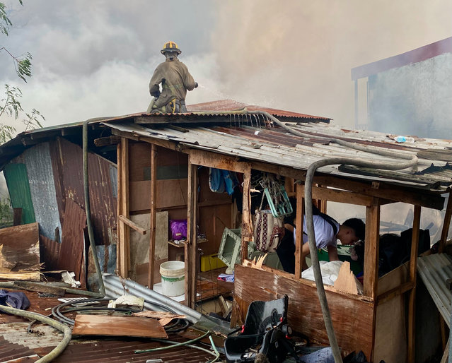 Firefighters try to extinguish a fire in a residential district of Las Pinas city, Metro Manila, Philippines, 15 October 2015. Close to a hundred families were left homeless after a fire broke out in a residential area in Barangay Talon Dos, Las Pinas city, according to the Bureau of Fire Protection. (Photo by Francis R. Malasig/EPA)