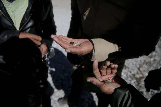 Tibetan people show to each other special pebbles found at the shore of Namtso lake in the Tibet Autonomous Region, China November 18, 2015. (Photo by Damir Sagolj/Reuters)
