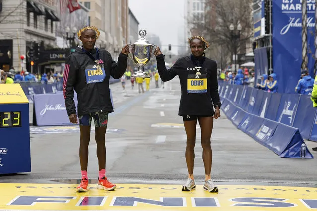 Evans Chebet and Hellen Obiri, both of Kenya, hold the trophy at the finish line after winning the 127th Boston Marathon, Monday, April 17, 2023, in Boston. (Photo by Winslow Townson/AP Photo)