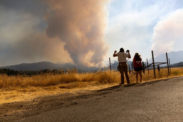 Residents reacts as they look at smoke rising from the Pickett Fire in Napa County, California, on August 22, 2025. (Photo by Carlos Barria/Reuters)