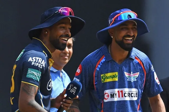 Gujarat Titans' captain Hardik Pandya (L) and his Lucknow Super Giants' counterpart Krunal Pandya smile during the toss before the start of the Indian Premier League (IPL) Twenty20 cricket match between Gujarat Titans and Lucknow Super Giants at the Narendra Modi Stadium in Ahmedabad on May 7, 2023. (Photo by Indranil Mukherjee/AFP Photo)
