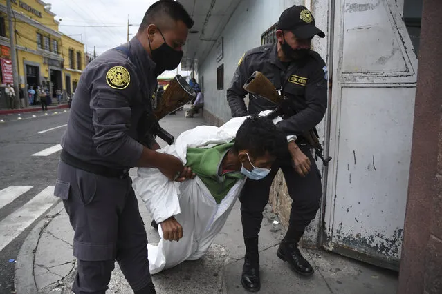 Penitentiary system guards carry an inmate with symptoms related to the novel coronavirus at the COVID-19 unit of San Juan de Dios hospital in Guatemala City on July 13, 2020. (Photo by Johan Ordonez/AFP Photo)