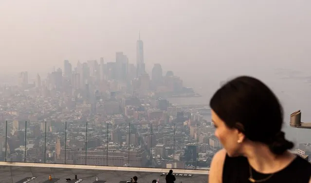 A woman looks at the Manhattan skyline engulfed in haze caused by smoke from wildfires burning in Canada, in New York, USA, 07 June 2023. (Photo by Justin Lane/EPA)