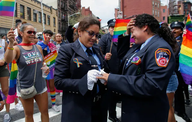 EMT Trudy Bermudez and paramedic Tayreen Bonilla of New York City Fire Department get engaged at the annual Pride Parade on June 24, 2018 in New York City. The first gay pride parade in the U.S. was held in Central Park on June 28, 1970. (Photo by Kena Betancur/Getty Images)