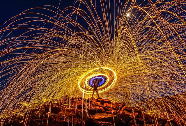 Light painting on the beach at Walton-on-the-Naze in Essex, United Kingdom on April 25, 2023 using burning steel wool spun around on a rope sending sparks flying. (Photo by Kevin Jay/Picture Exclusive)
