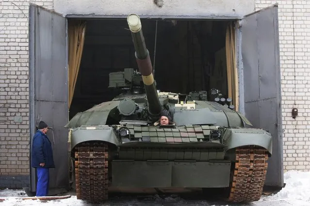 An employee drives a modernized T-72 battle tank at the Kyiv Armoured Plant before the ceremony of handing over to the servicemen of Ukrainian armed forces in Kyiv, Ukraine on February 24, 2021. (Photo by Valentyn Ogirenko/Reuters)