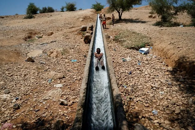 Palestinians cool off during a heat wave, in al-Oja springs near Jericho in the Israeli-occupied West Bank on July 18, 2023. (Photo by Ammar Awad/Reuters)