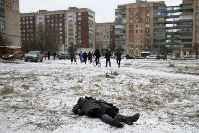 The body of a woman killed by recent shelling lies on a street in the residential sector in the town of Kramatorsk, eastern Ukraine February 10, 2015. (Photo by Gleb Garanich/Reuters)