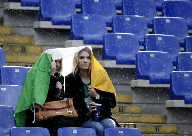 Irish fans shelter from light rain with their national flag, prior to the start of the Six Nations Rugby Union match between Italy and Ireland at Rome's Olympic stadium, Saturday, February 7, 2015. (Photo by Gregorio Borgia/AP Photo)