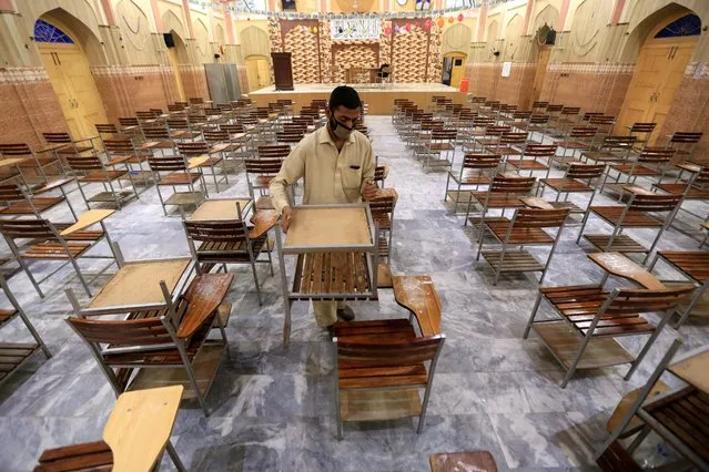 A worker cleans an examination hall in a school building after all educational institutes closed in Peshawar, Pakistan, 15 March 2021. The Federal Minister for Education Shafqat Mehmood during a press conference with Special Assistant to the Prime Minister on Health Dr Faisal Sultan at the National Command and Operations Centre (NCOC) on 10 March decided to close all educational institutions of Peshawar Khyber pakhtunkhwa from 15 March to 28 March and conduct online classes during the time period as the number of Covid-19 case in the country continue to increase. (Photo by Bilawal Arbab/EPA/EFE)