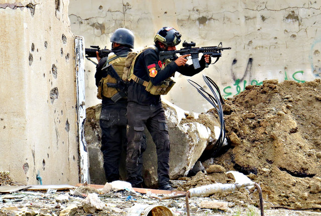 Iraqi forces secure an area near the Grand Mosque in central Ramadi, the capital of Iraq's Anbar province, on January 8, 2016, after retaking the city from Islamic State (IS) group jihadists. Iraqi forces pushed out of central Ramadi on January 1, 2016 to extend their grip on the city, sweeping neighbourhoods for pockets of jihadists to flush out and trapped civilians to evacuate. (Photo by AFP Photo/Stringer)
