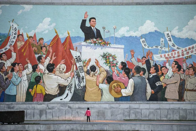 A child stands before a propaganda mosaic in Pyongyang, North Korea on December 1, 2016. (Photo by Ed Jones/AFP Photo)