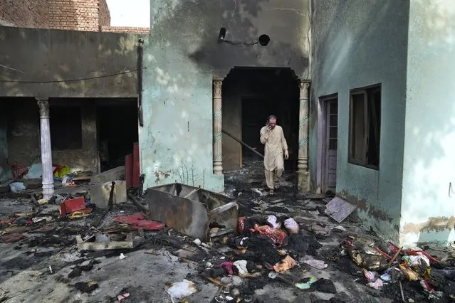 A Christian man looks at a home vandalized by an angry Muslim mob in Jaranwala in the Faisalabad district, Pakistan, Thursday, August 17, 2023. Police arrested more than 100 Muslims in overnight raids from an area in eastern Pakistan where a Muslim mob angered over the alleged desecration of the Quran by a Christian man attacked churches and homes of minority Christians, prompting authorities to summon troops to restore order, officials said Thursday. (Photo by K.M. Chaudary/AP Photo)