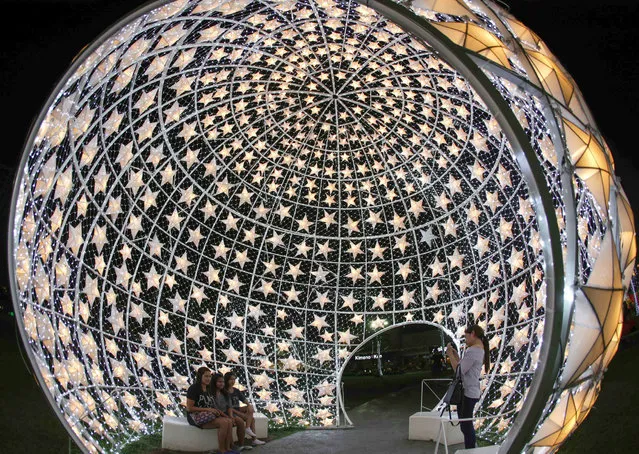 Filipinos have their picture taken inside a dome decorated with Christmas lanterns at a park in Pasay City, south of Manila, Philippines, 20 December 2016. (Photo by Mark R. Cristino/EPA)
