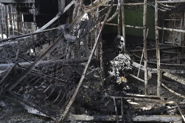 A burned out body of Ukrainian military prisoner is seen in destroyed barrack at a prison in Olenivka, in an area controlled by Russian-backed separatist forces, eastern Ukraine, Friday, July 29, 2022. Russia and Ukraine accused each other Friday of shelling the prison in Olenivka in a separatist region of eastern Ukraine, an attack that reportedly killed dozens of Ukrainian military prisoners who were captured after the fall of a southern port city of Mariupol in May. (Photo by AP Photo/Stringer)