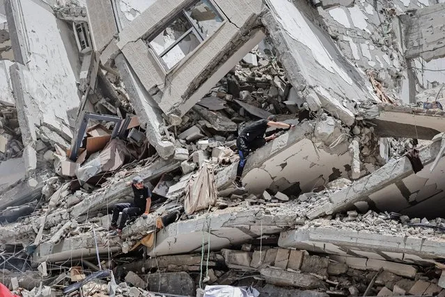 Palestinian workers clear the rubble and debris in Gaza City's al-Rimal neighbourhood, which was targeted by Israeli strikes during the recent confrontation between Hamas and Israel, on June 8, 2021. (Photo by Mohammed Abed/AFP Photo)