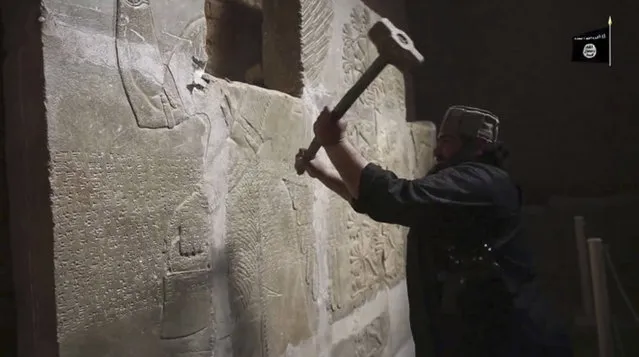This image made from video posted online by Islamic State militants in April 2015 shows a militant taking a sledgehammer to a stone carving at the ancient site of Nimrud near Mosul, Iraq. Militants blew up and hacked apart much of the nearly 3,000-year-old city’s remains, destroying one of the Mideast’s most important archaeological sites. Nearly a month after the extremists were driven out, the site is still in danger, with the wreckage unprotected and vulnerable to being stolen. (Photo by Militant video via AP Photo)
