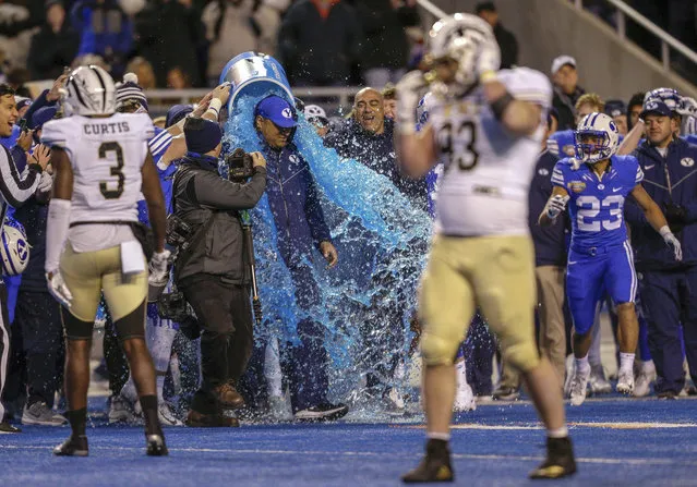 BYU coach Kalani Sitake is doused at the end of the team's 49-18 win over Western Michigan in the Famous Idaho Potato Bowl NCAA college football game Friday, December 21, 2018, in Boise, Idaho. (Photo by Steve Conner/AP Photo)