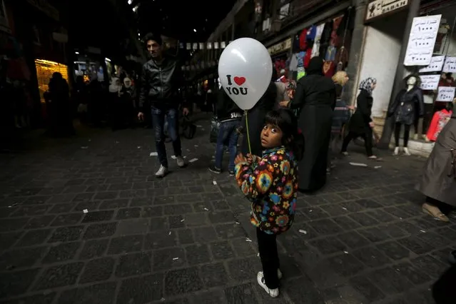 A girl carries a balloon ahead of Valentine's Day in al-Hamidiyah Souq, in Damascus, Syria February 11, 2016. Picture taken February 11, 2016. (Photo by Omar Sanadiki/Reuters)