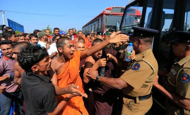 A Sri Lankan Buddhist monk and villagers argue with police officers during a protest outside the inauguration ceremony of an industrial zone in Mirijjawila village in Ambalantota, Sri Lanka, Saturday, January 7, 2017. Sri Lankan police used water cannons to try to break up violent clashes Saturday between government supporters and villagers marching against what they say is a plan to take over private land for an industrial zone in which China will have a major stake. The government has signed a framework agreement for a 99-year lease of the Hambantota port with a company in which China will have 80-percent ownership. Officials also plan to set up the nearby industrial zone where Chinese companies will be invited to set up factories. (Photo by Eranga Jayawardena/AP Photo)