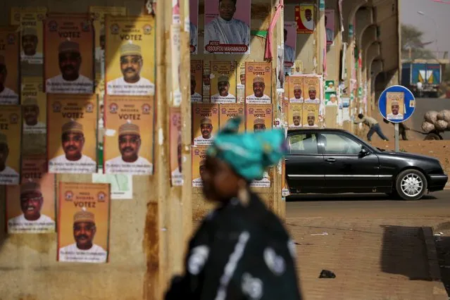 A woman walks past electoral campaign posters for presidential candidate Seini Oumarou in Niamey, Niger, February 16, 2016. Niger holds presidential and legislative elections on Sunday. (Photo by Joe Penney/Reuters)