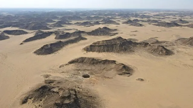 An aerial view taken on June 6, 2021 shows the Well of Barhout known as the “Well of Hell” in the desert of Yemen's Al-Mahra province. Closer to the border with Oman than to the capital Sanaa 1,300 kilometres (800 miles) away, the giant hole in the desert of Al-Mahra province is 30 metres wide and thought to be anywhere between 100 and 250 metres deep. Local folklore says it was created as a prison for the demons – a reputation bolstered by the foul odours rising from its depths. (Photo by AFP Photo/Stringer)