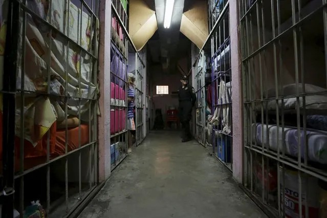 A police officer stands guard next to a female inmate in the Topo Chico prison during a media tour in Monterrey, Mexico, February 17, 2016. (Photo by Daniel Becerril/Reuters)