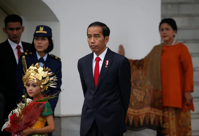 Indonesian President Joko Widodo (C) and his wife Iriana (R) wait for the arrival of Japanese Prime Minister Shinzo Abe at the Bogor Palace, West Java, Indonesia January 15, 2017. (Photo by Reuters/Beawiharta)