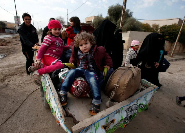 Displaced children sit in a cart as they flee during a battle with Islamic State militants, in al-Zuhoor neighborhood of Mosul, Iraq, January 8, 2017. (Photo by Azad Lashkari/Reuters)