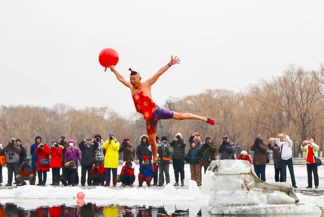 A man wearing a costume dives into a partly frozen lake in Shenyang, in China's northeastern Liaoning province on February 19, 2019. (Photo by AFP Photo/China Stringer Network)