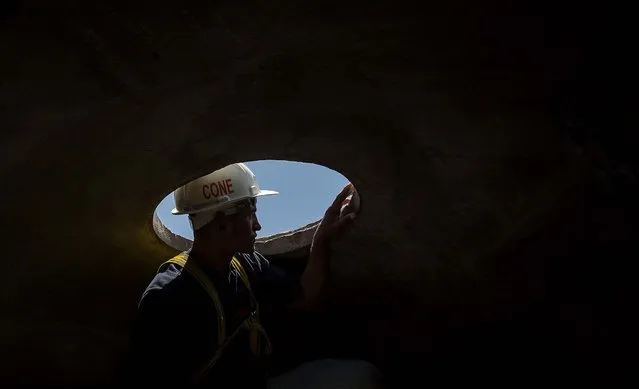 A worker looks out from inside the head of the Christ Redeemer statue. (Photo by Felipe Dana/Associated Press)