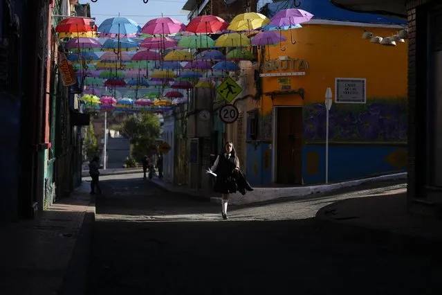 A student walks past the Calle de las Violetas in La Candelaria, a downtown neighborhood of Bogota, Colombia, Wednesday, November 22, 2023. (Phoot by Fernando Vergara/AP Photo)
