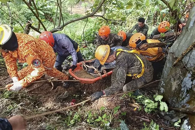 In this handout photo provided by the Municipality of Monkayo, rescuers retrieve a body of one of the victims after a landslide due to heavy rains at Monkayo town in Davao de Oro province, southern Philippines on Friday, January 19, 2024. A landslide set off by days of heavy rain buried a house in the southern Philippines where people were holding Christian prayers, killing multiple people, including children, and seriously injuring some others, a disaster-response official said. (Photo by Municipality of Monkayo via AP Photo)