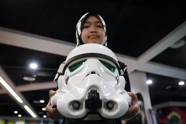 A Malaysian Muslim girl poses with a Storm Trooper helmet at a Star Wars Day gathering in a mall downtown Kuala Lumpur, Malaysia, Saturday, May 2, 2015. Star Wars Day is observed by fans globally on May 4 with a slight change in the iconic catchphrase; from “May the Force be with you” to “May the Fourth be with you”. (Photo by Joshua Paul/AP Photo)