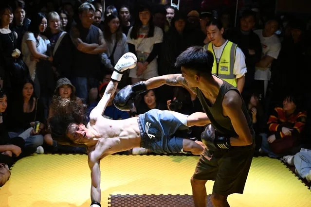 Two men fight during a competition held for entertainment at an industrial building on the third day of the Lunar New Year of the Dragon in Hong Kong on February 12, 2024. (Photo by Peter Parks/AFP Photo)