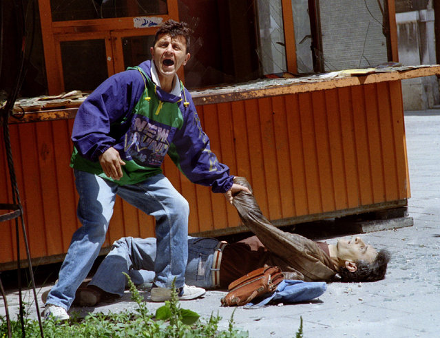 A man yells for help minutes after a Serb shell hit a crowded pedestrian walkway in Sarajevo, May 1993.  Radovan Karadzic, a 70-year-old former psychiatrist, still in robust health, is the most senior political figure to be convicted by the International Criminal Tribunal for the Former Yugoslavia. He was found guilty of 10 out of 11 charges. He was acquitted of a second count of genocide in Bosnian towns. (Photo by Reuters)