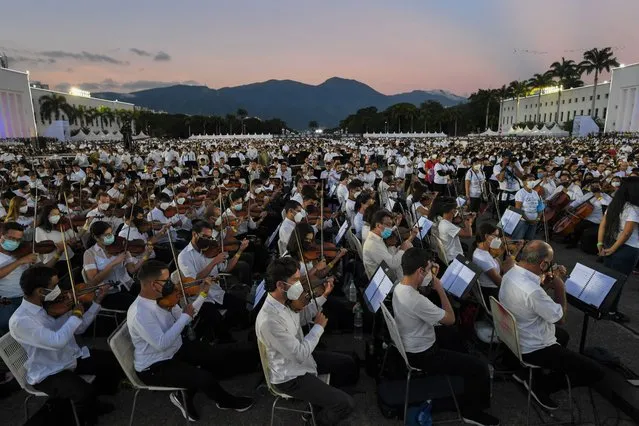 Members of the National System of Orchestras of Venezuela play during an attempt to enter the Guinness Book of Records for the largest orchestra in the world, with more than 12,000 musicians, at the Military Academy of the Bolivarian Army in Fuerte Tiuna Military Complex, in Caracas, on November 13, 2021. (Photo by Federico Parra/AFP Photo)